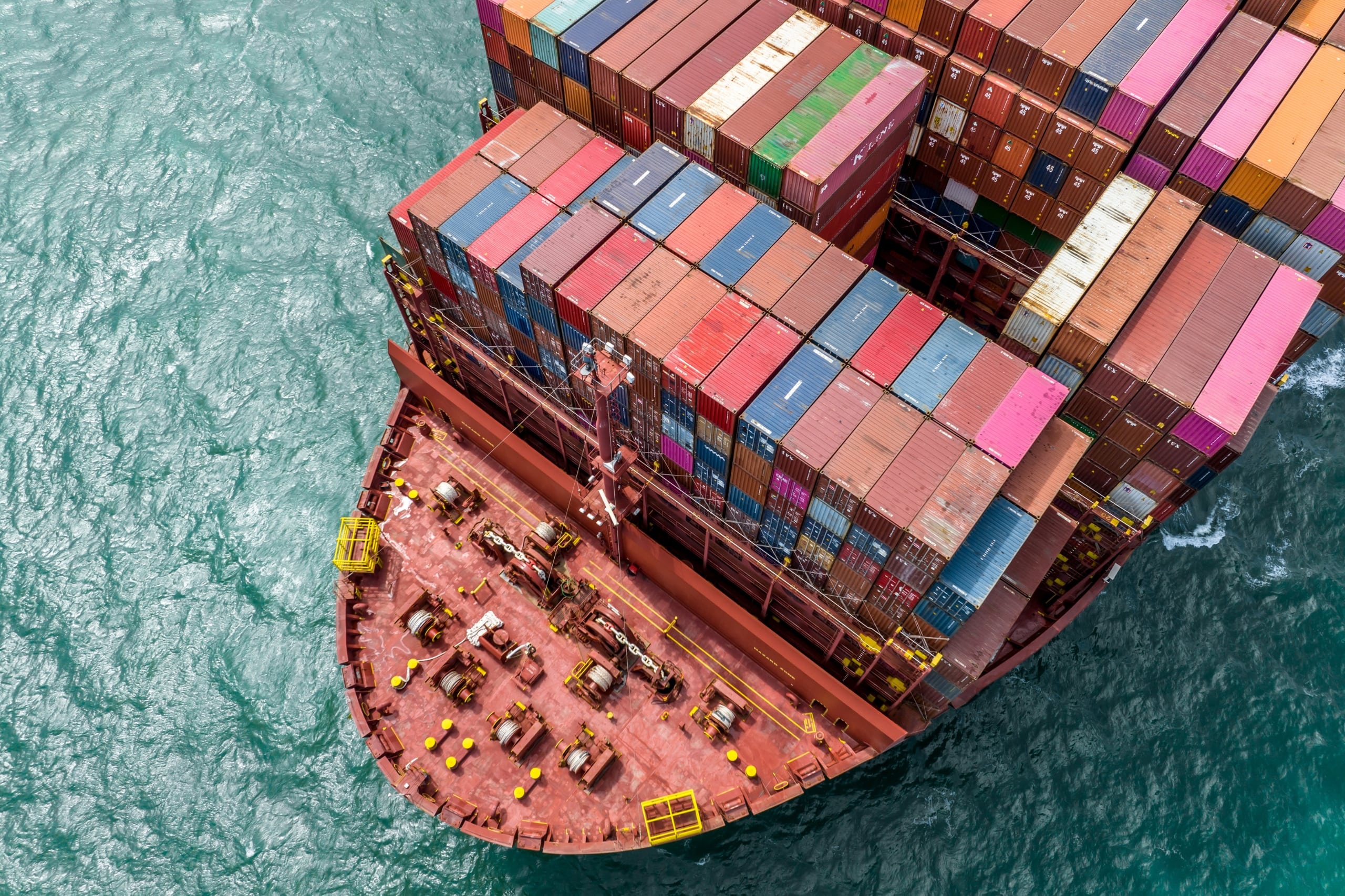 Aerial view of a container ship’s stern showing mechanical deck and shaft area at sea